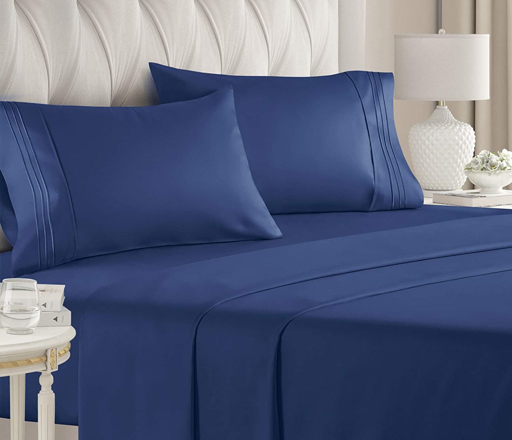 navy blue sheets on neatly made bed in traditional room