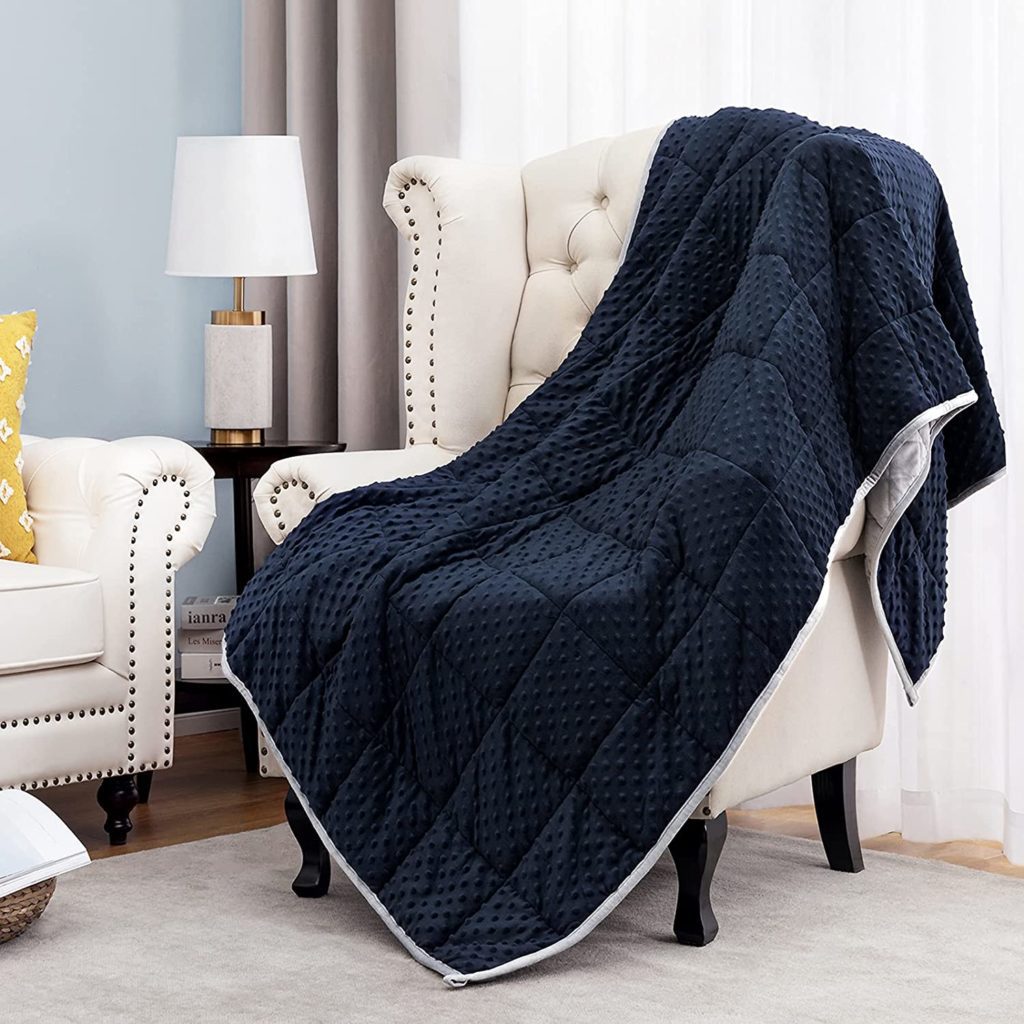navy blue textured blanket draped over sitting chair