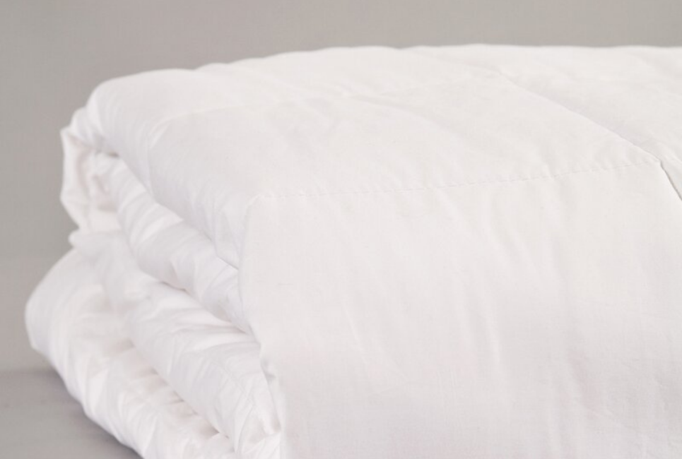 neatly folded white silk comforter