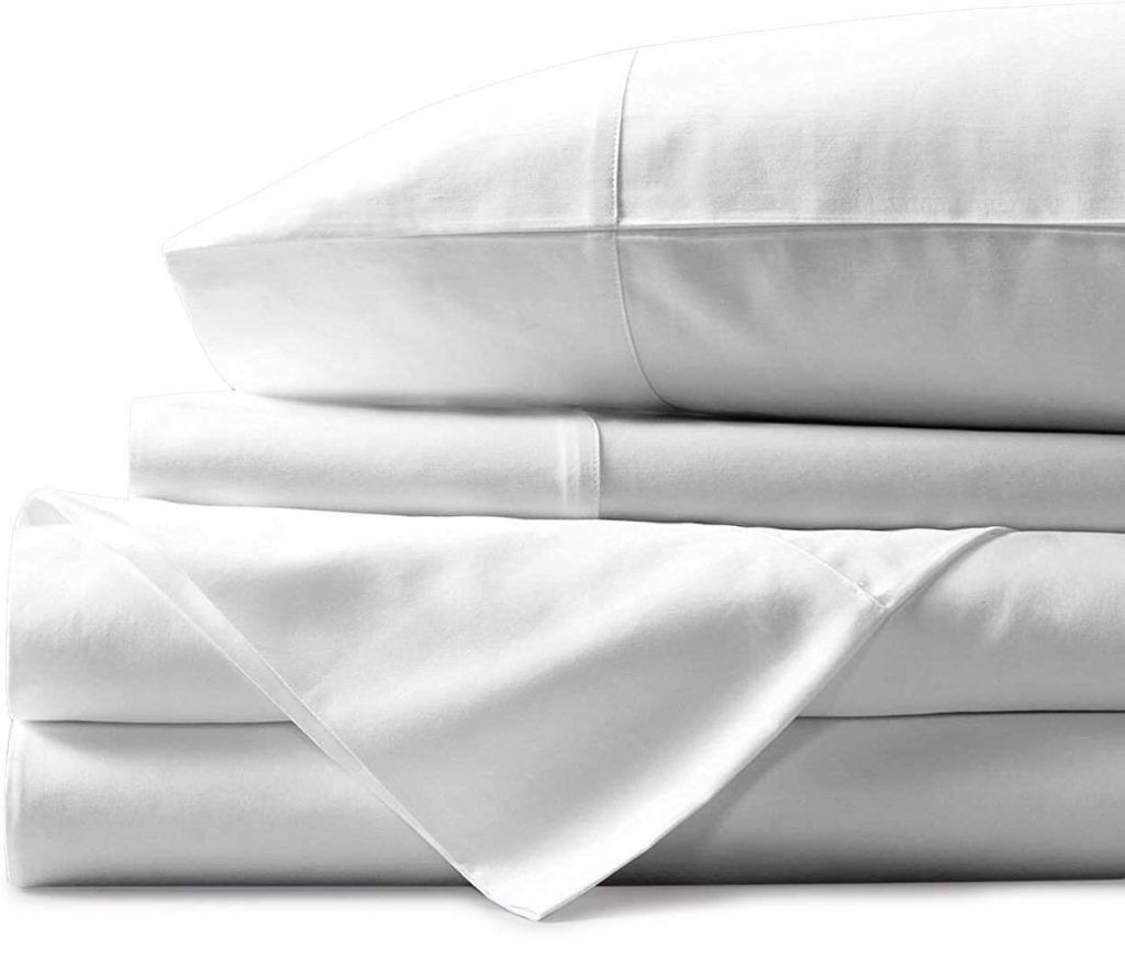 neatly folded white stacked sheets and pillow