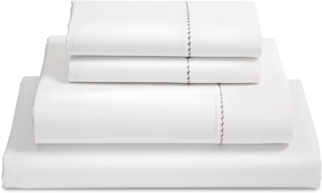 neatly folded white stacked sheets with scalloped detail
