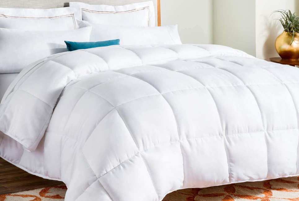 neatly made bed with white box stitch comforter and one blue pillow