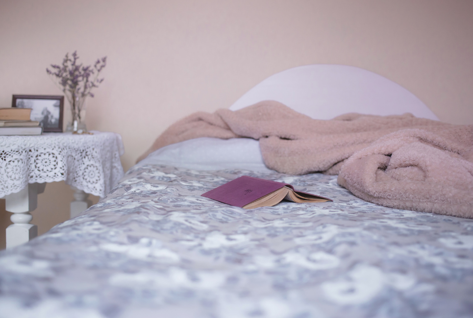 open book resting on bed with patterened bedding