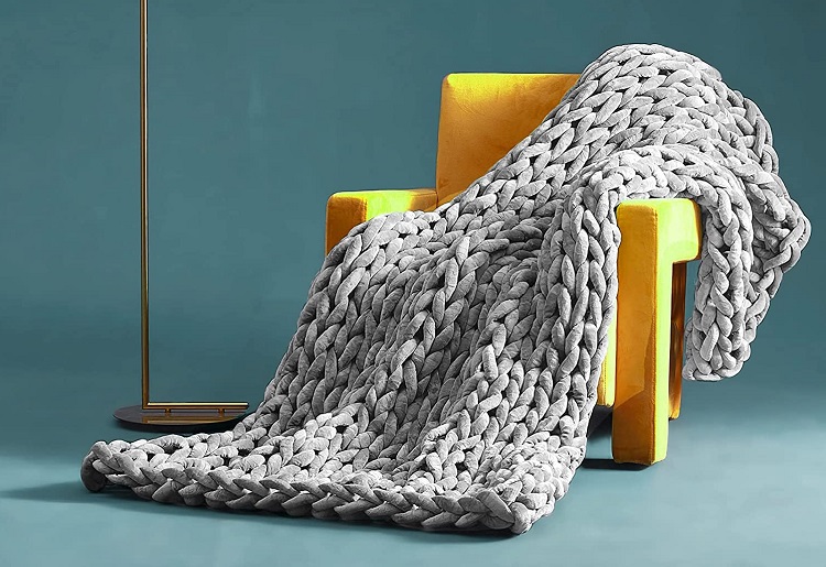 oversized knit grey blanket draped over yellow chair