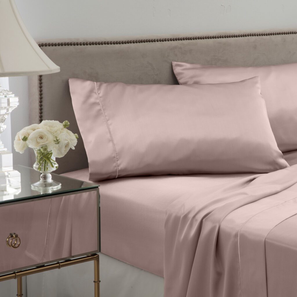 pink satin sheets and pillow on bed in elegant room