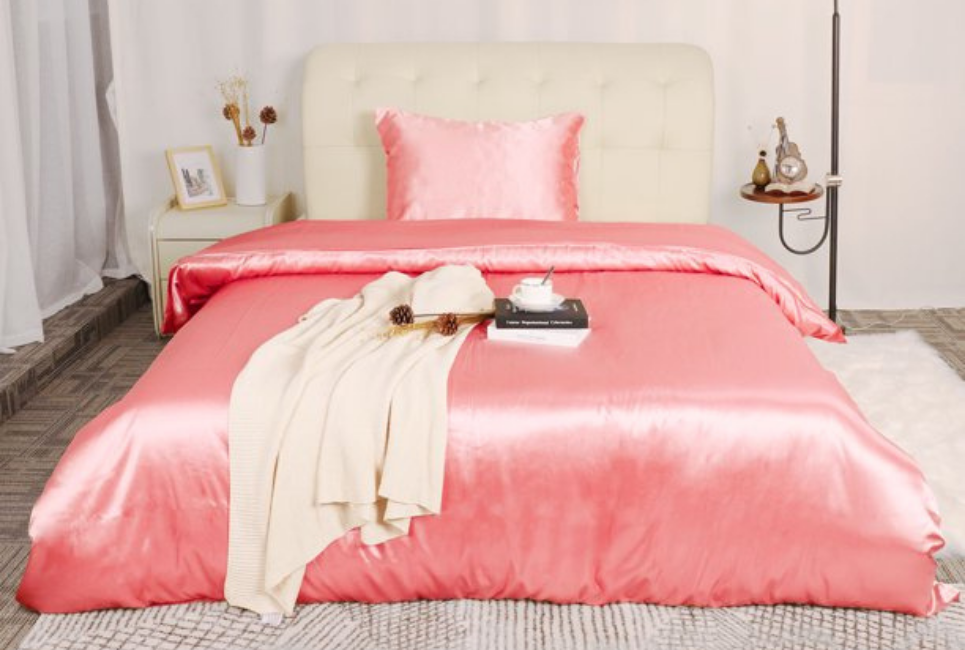 pink silk comforter and sheets on bed in trendy room