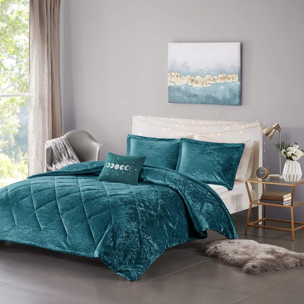 plush teal comforter on bed in cozy room