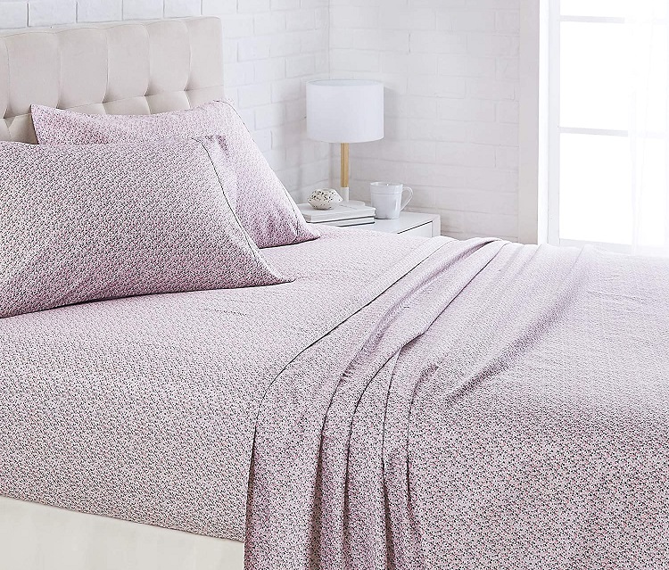 purple and white sheets with small floral pattern on bed