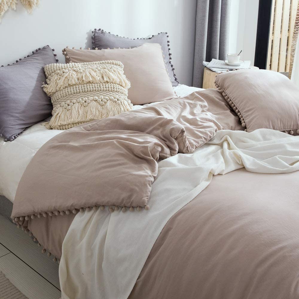 slightly messy taupe and neutral comforter on bed