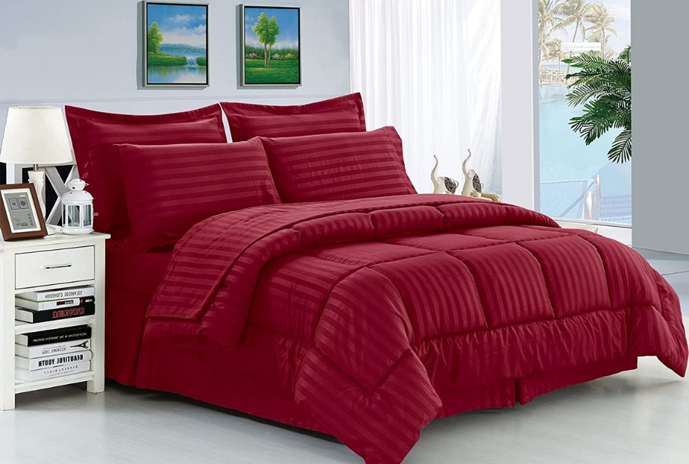 striped burgundy red comforter and pillows on bed