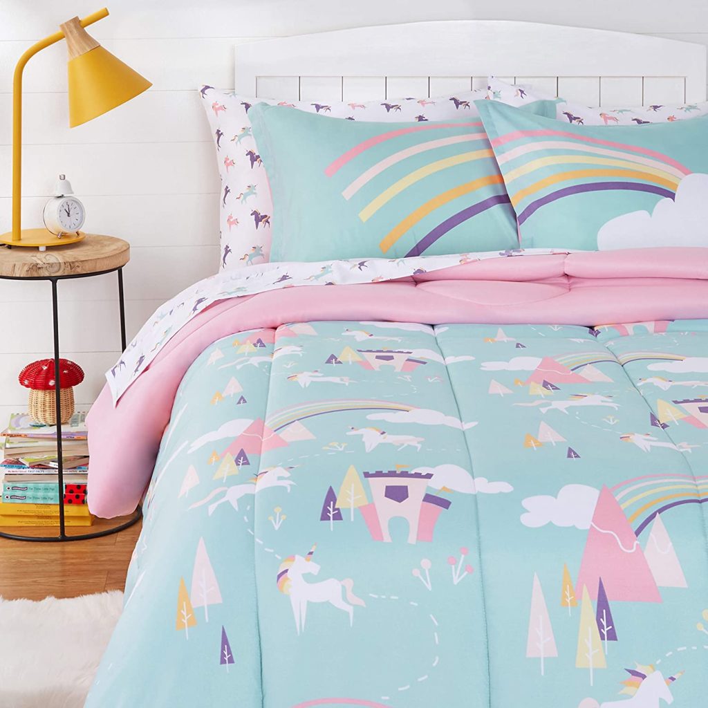 teal rainbow and unicorn comforter set on bed