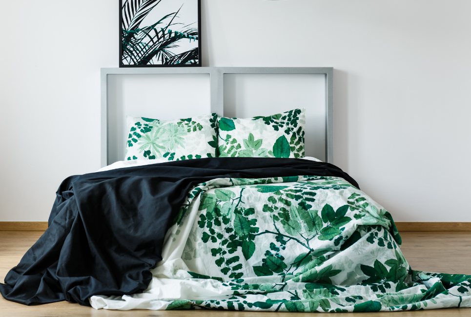 unmade bed with botanical watercolor print bedding