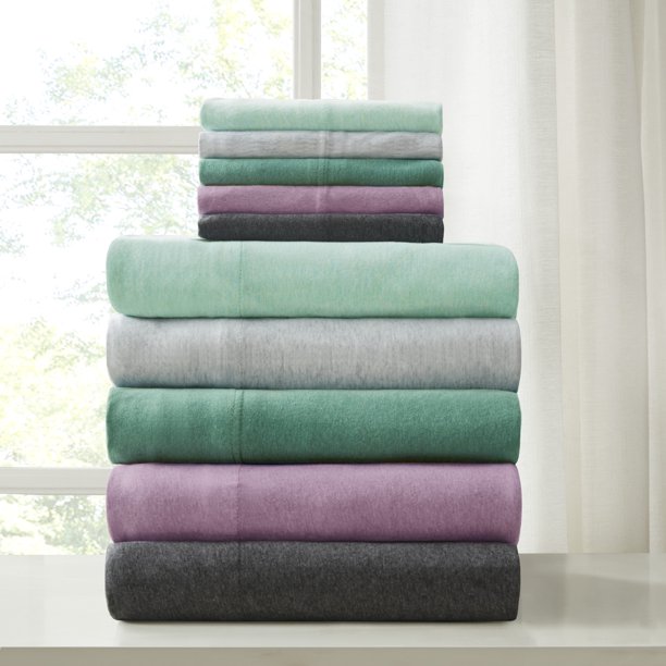 various purple teal and grey colors of folded sheets stacked up