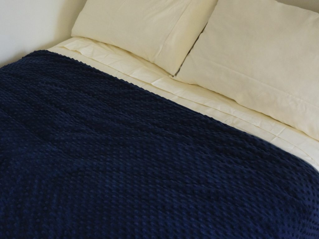 navy blue weighted blanket on neat bed