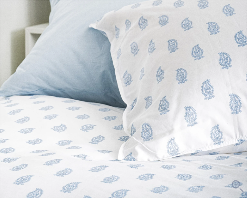white cotton sheets on bed with blue paisley pattern
