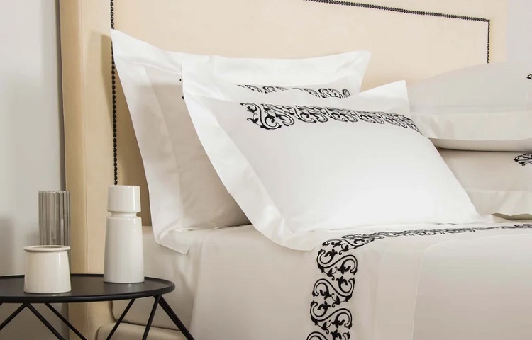 white pillowcase and sheets with black brocade trim