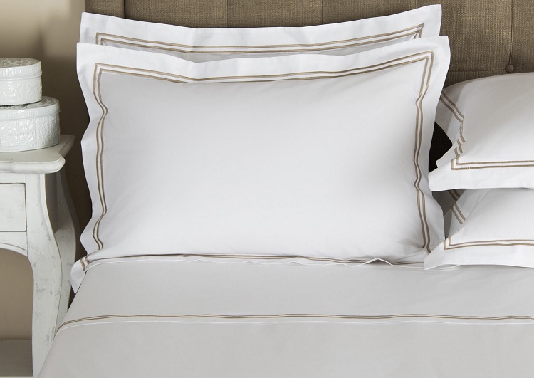 white pillowcase and sheets with elegant gold trim