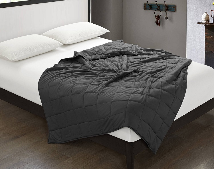 white sheets on bed with dark grey weighted blanket