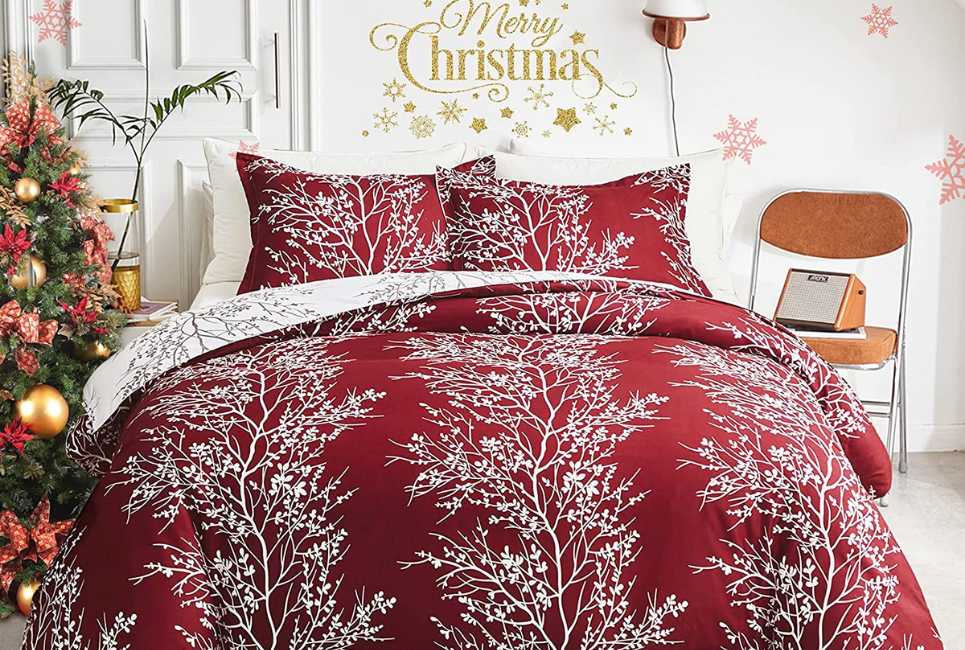 white tree branch pattern on red burgundy comforter with merry christmas sign above bed