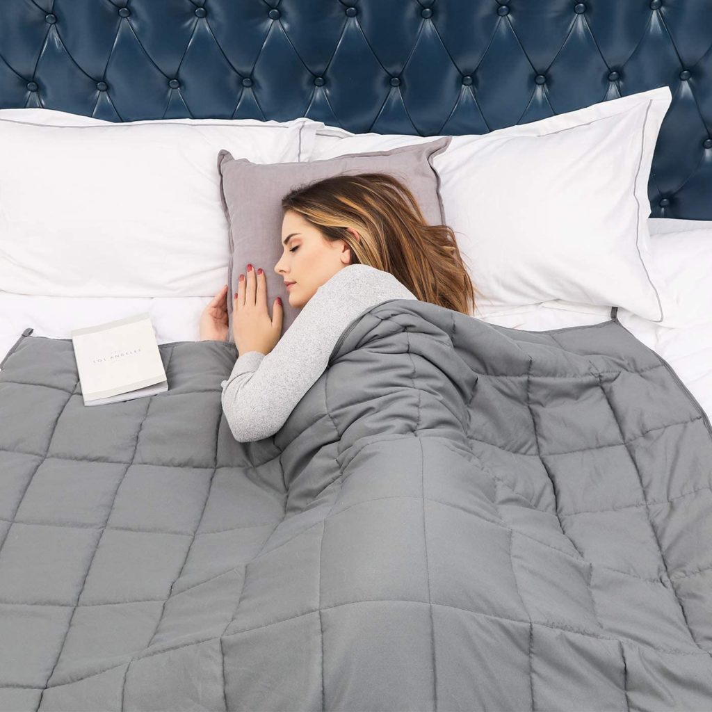 woman sleeping peacefully in bed with grey blanket