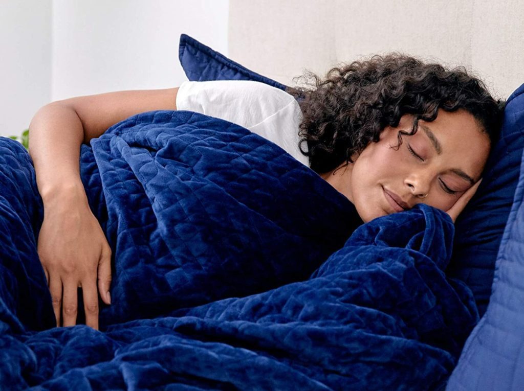 woman sleeping peacefully on side under blue blanket
