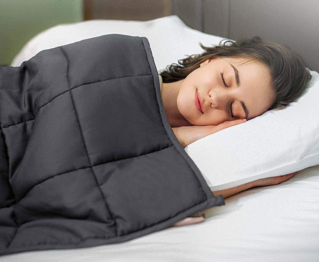 woman sleeping peacefully under grey blanket