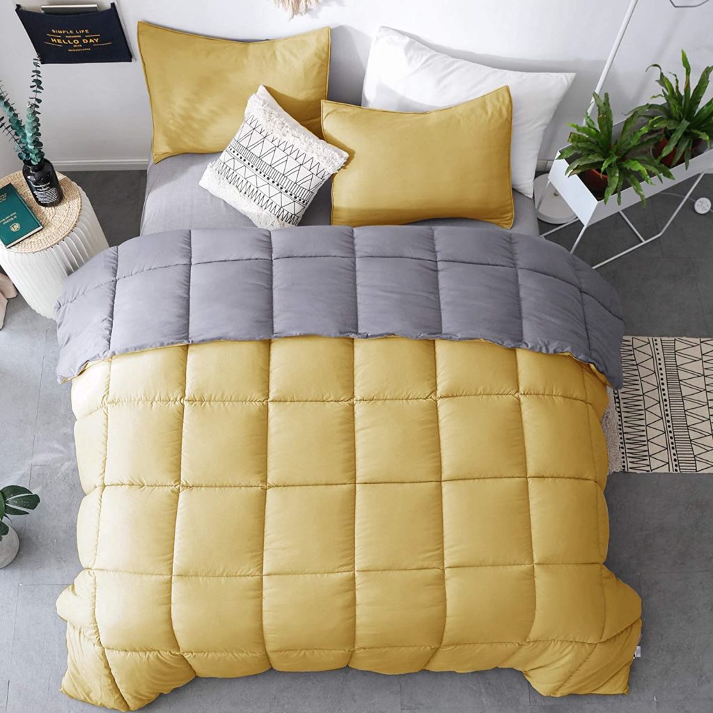 yellow and grey reversible comforter on bed