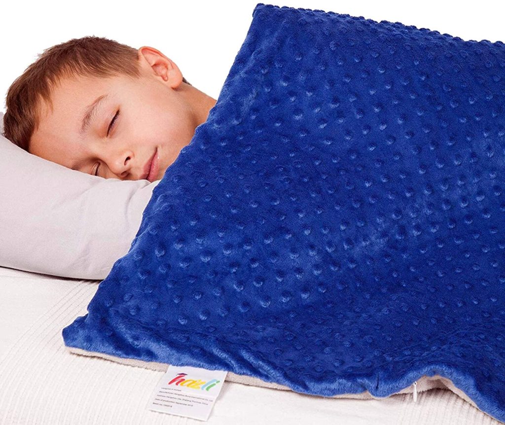 young child sleeping under blue velvet weighted blanket