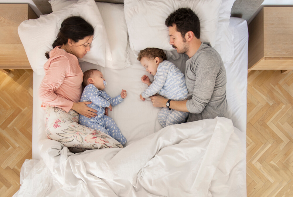 young family cosleeping in bed
